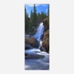 A vertical panoramic photograph of a beautiful cascading waterfall surrounded by forest and rocks, ideal for wall decor.