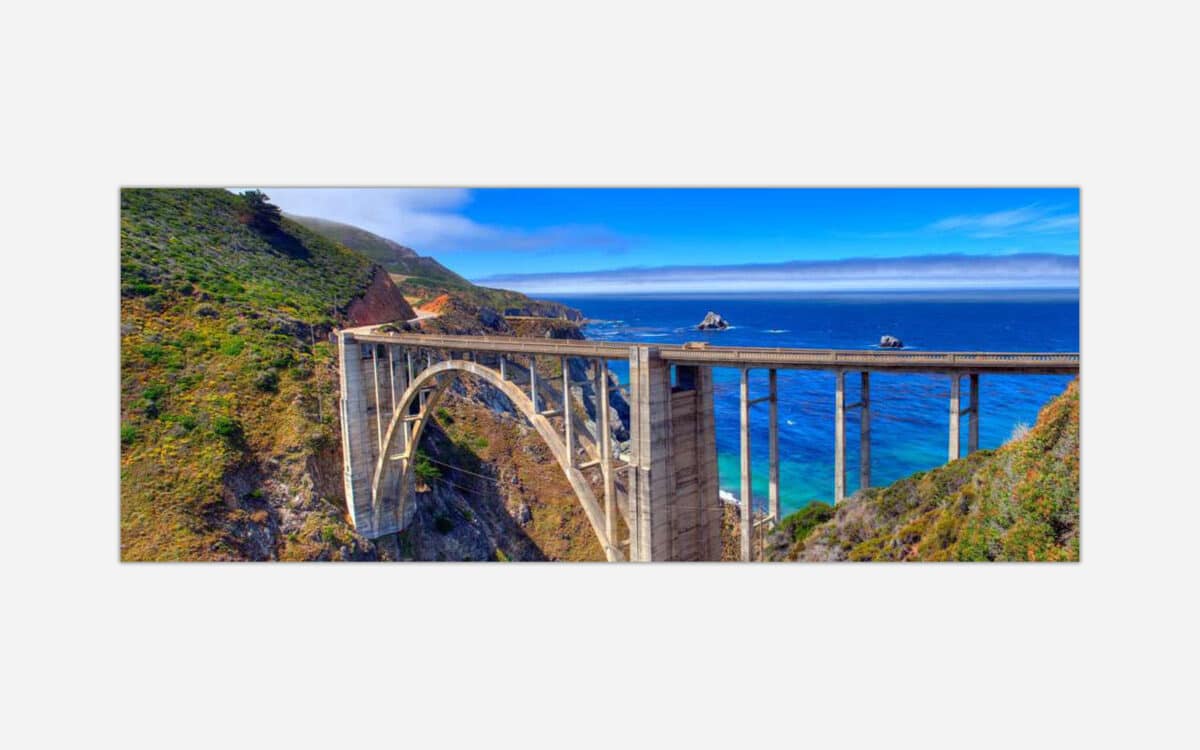 A panoramic photograph of the Bixby Bridge along the Big Sur coastline with the Pacific Ocean in the background.