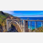 A panoramic photograph of the Bixby Bridge along the Big Sur coastline with the Pacific Ocean in the background.