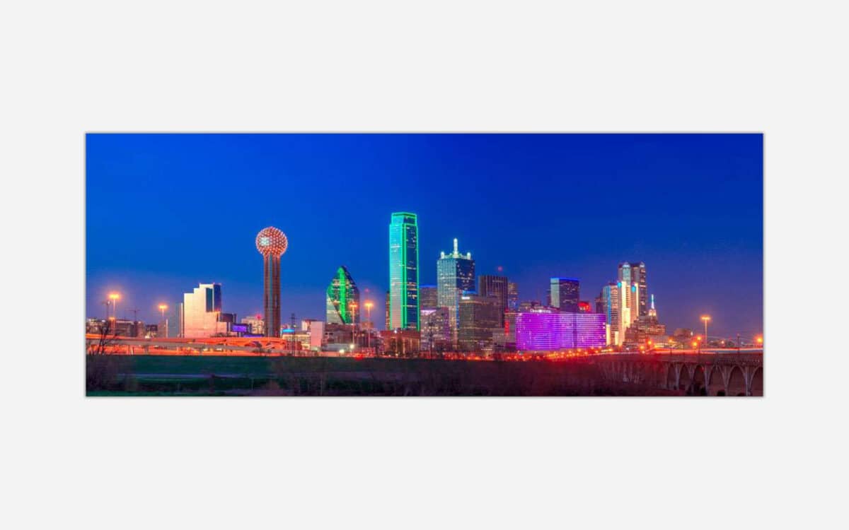An image of the Dallas, Texas skyline at dusk featuring illuminated buildings and a clear sky.