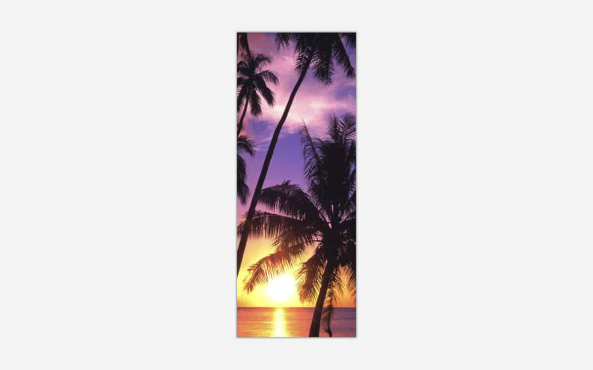 A tall vertical canvas print of a serene tropical sunset with palm tree silhouettes against a purple sky over the ocean.