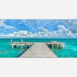 A vibrant art piece featuring a wooden pier extending into the turquoise waters of a tropical ocean with fluffy clouds in the sky.