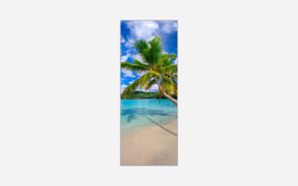 A vibrant vertical art piece featuring a lush palm tree leaning over a crystal clear turquoise beach with white sand and a serene blue sky with fluffy clouds.