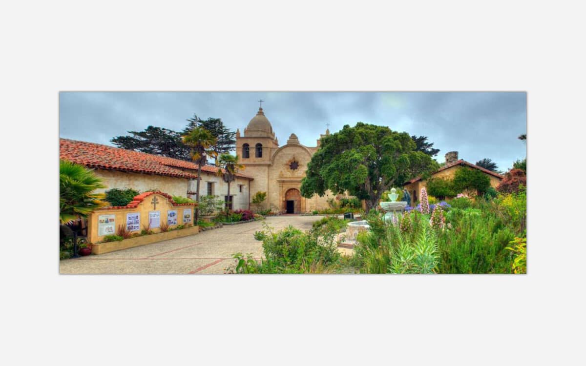 A high dynamic range (HDR) image of a historic California mission with Spanish colonial architecture surrounded by a lush garden and a fountain in the courtyard.