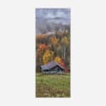 An image of a rustic cabin in a forest during autumn with vibrant fall foliage and misty mountains in the background.
