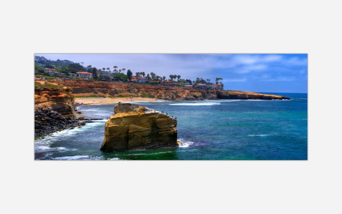 A vibrant painting of a coastal seascape featuring cliffs, a sandy beach, and waves rolling into the shore under a partly cloudy sky.