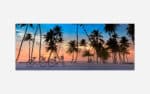 An art print of a serene beach sunset with silhouettes of palm trees and bicycles on white sand, under a pastel-colored sky.