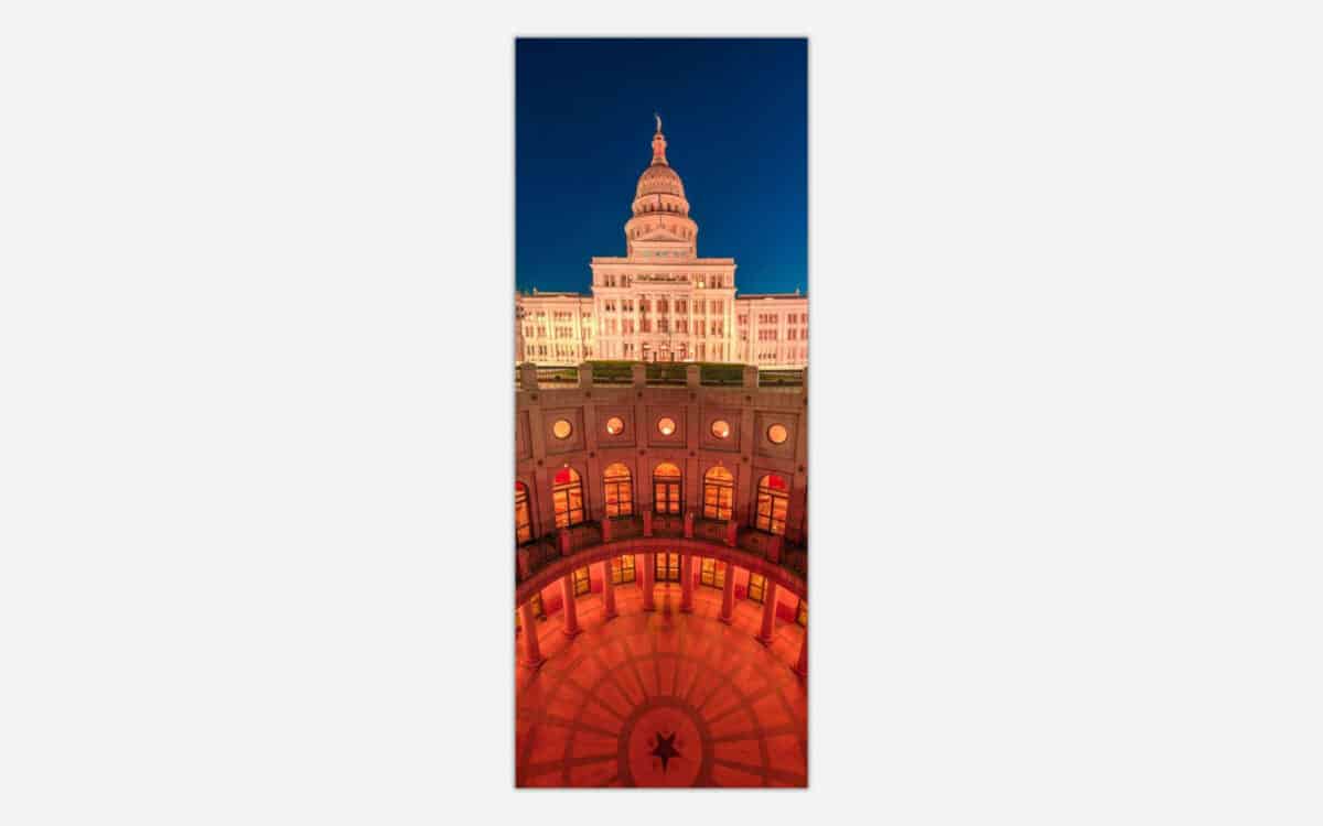 An illuminated view of the Texas State Capitol building at night with a dramatic sky, showcasing the architectural details and grandeur of the historic edifice.