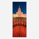 An illuminated view of the Texas State Capitol building at night with a dramatic sky, showcasing the architectural details and grandeur of the historic edifice.