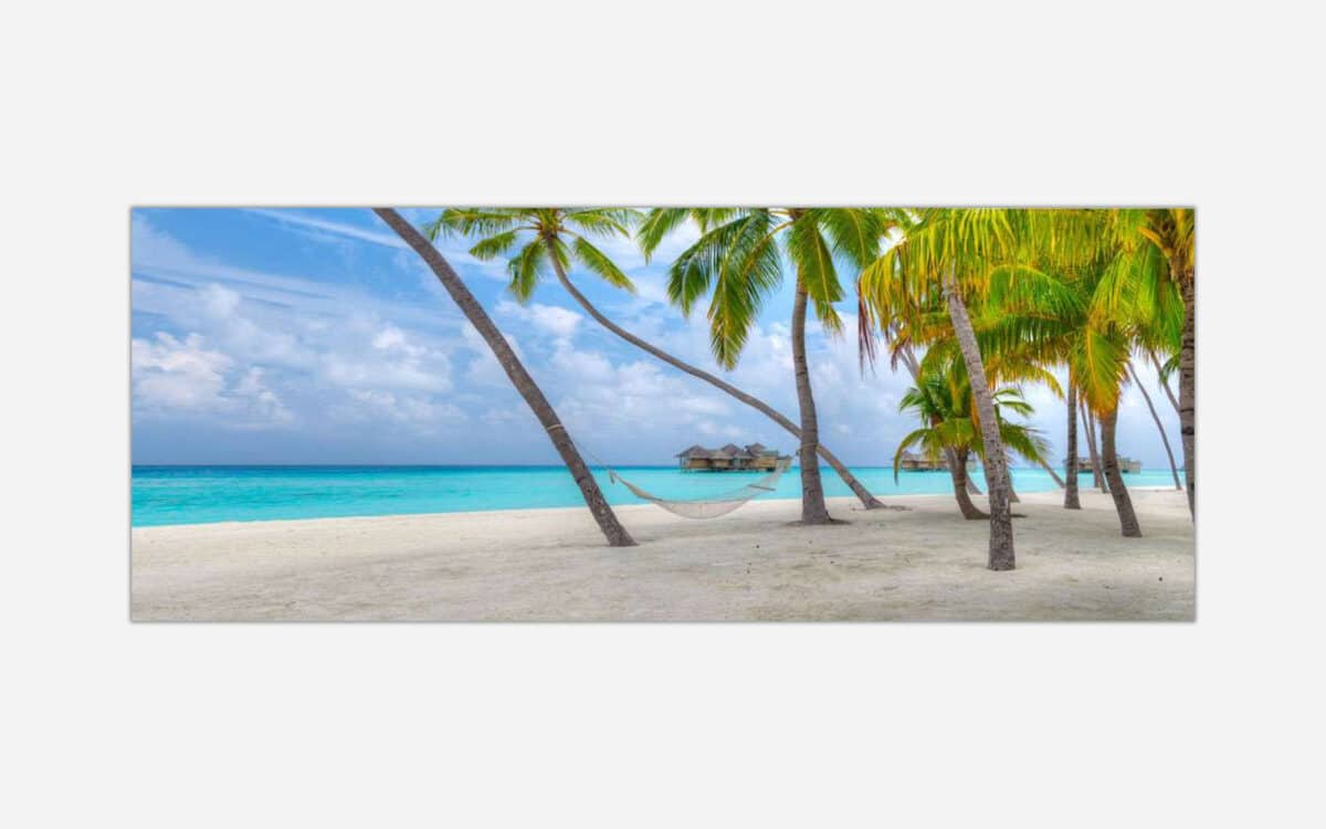 A serene tropical beach scene with palm trees, a hammock, and an overwater bungalow in the background against a turquoise sea.